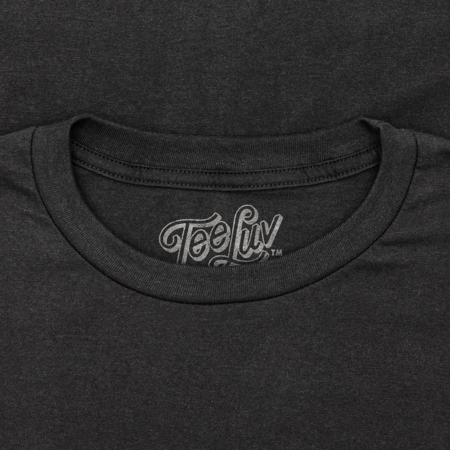 Close-up of a black t-shirt with 'Tee Luv' logo on the collar.