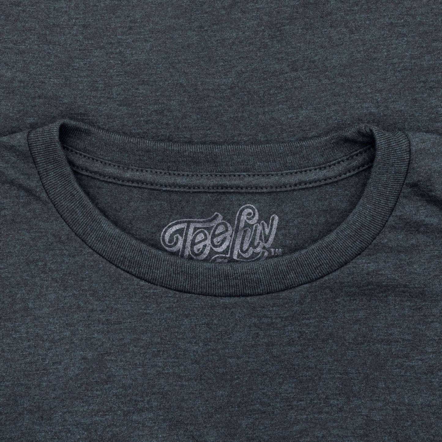 Close-up of a dark gray t-shirt with 'Tee Luv' logo on the neckline.