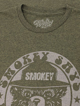Green t-shirt with 'Smokey Skys' graphic design and 'Teefly' branding.