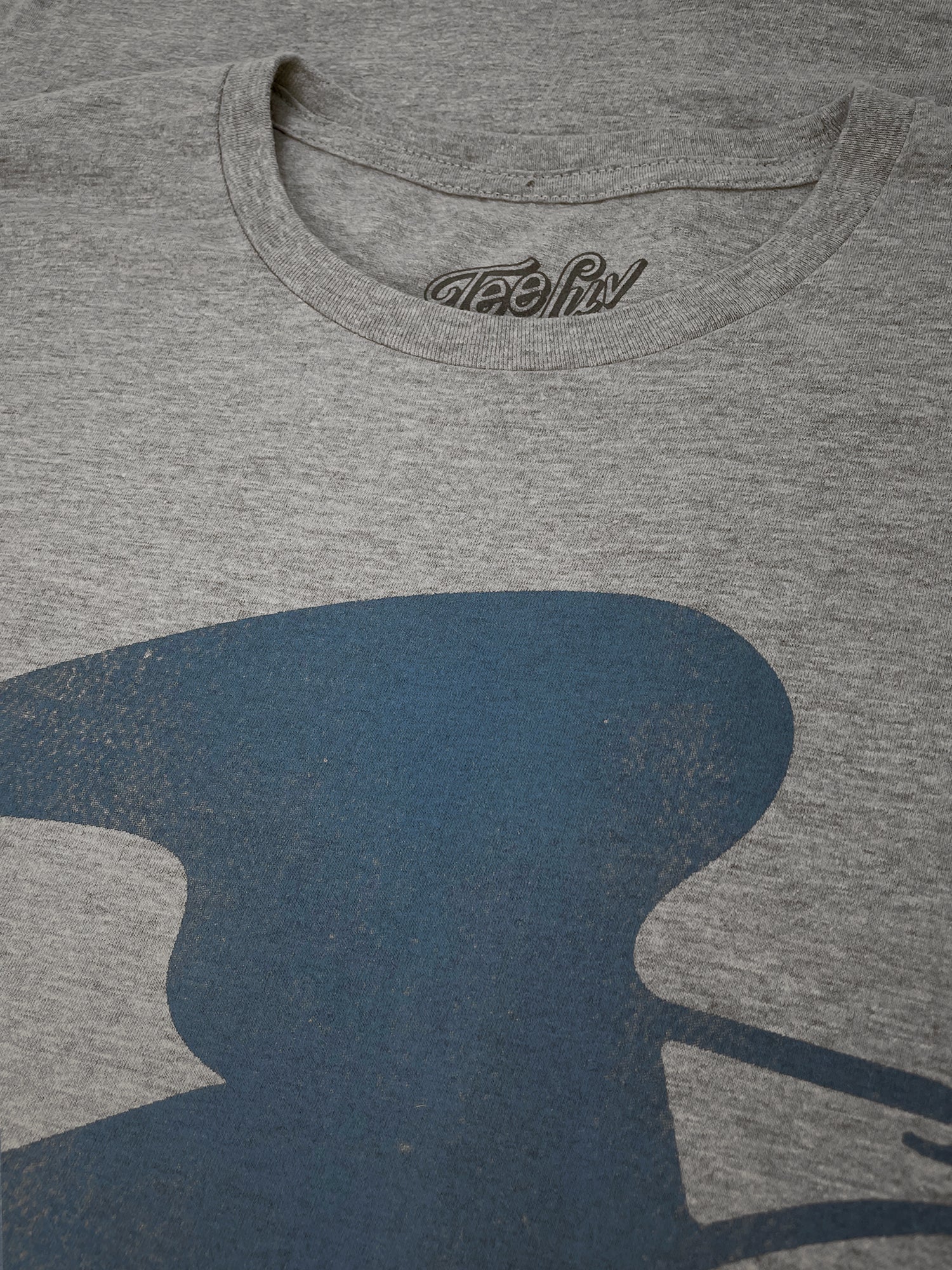 Gray t-shirt with a blue graphic design on a plain background