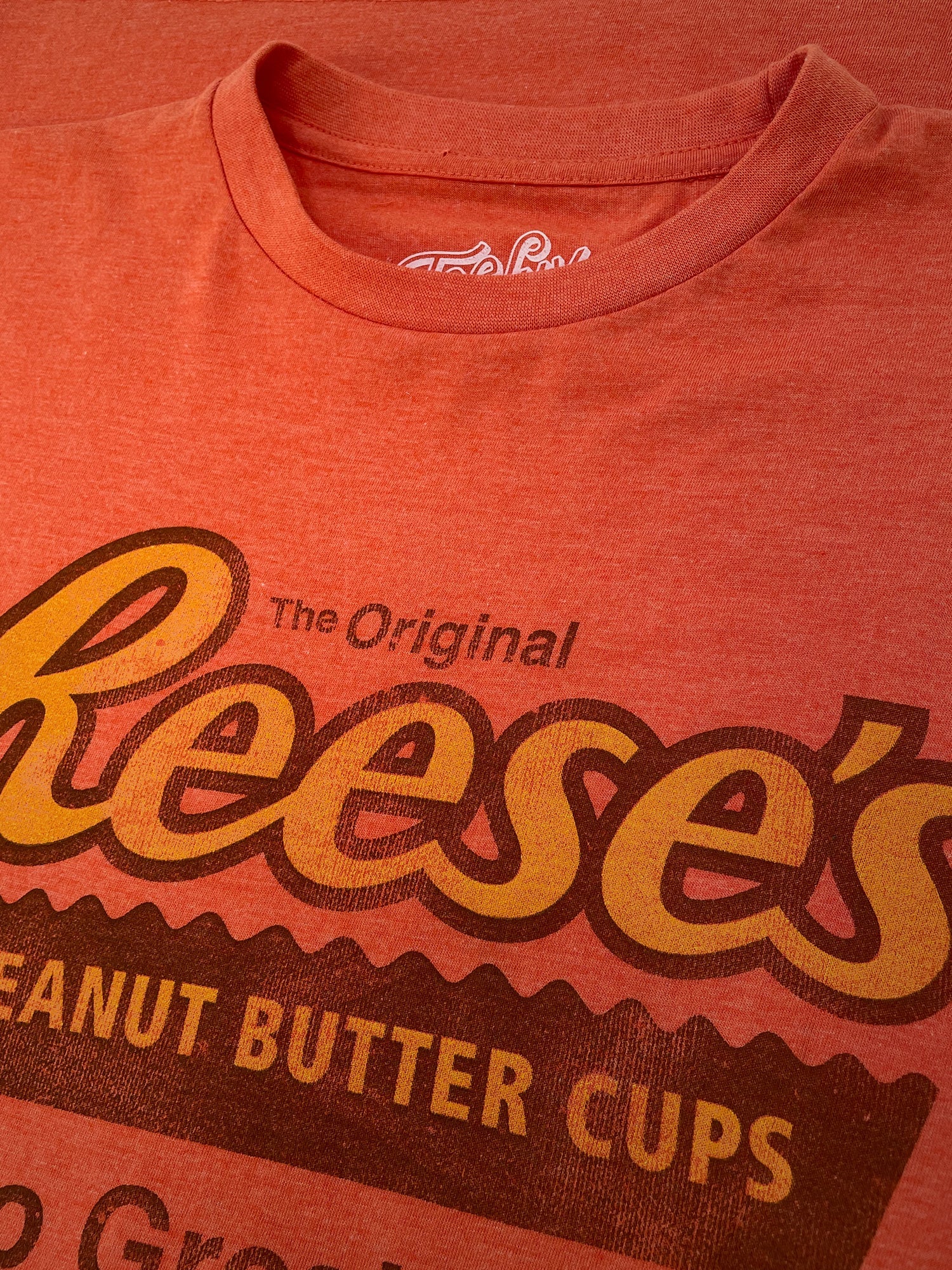 Red t-shirt with Reese's Peanut Butter Cups logo on a red background