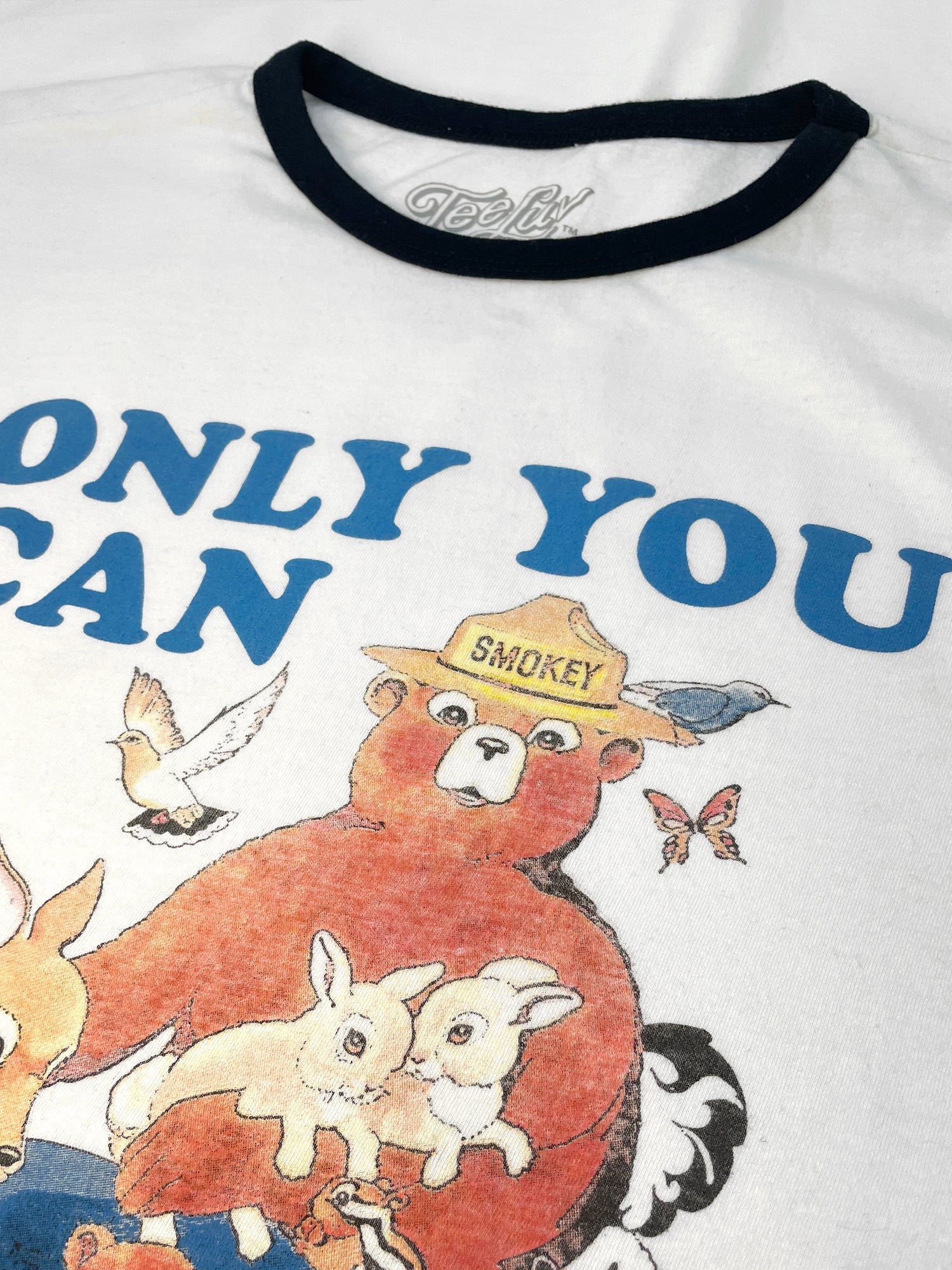T-shirt with cartoon bear and text 'ONLY YOU CAN' featuring Smokey Bear and other animals.