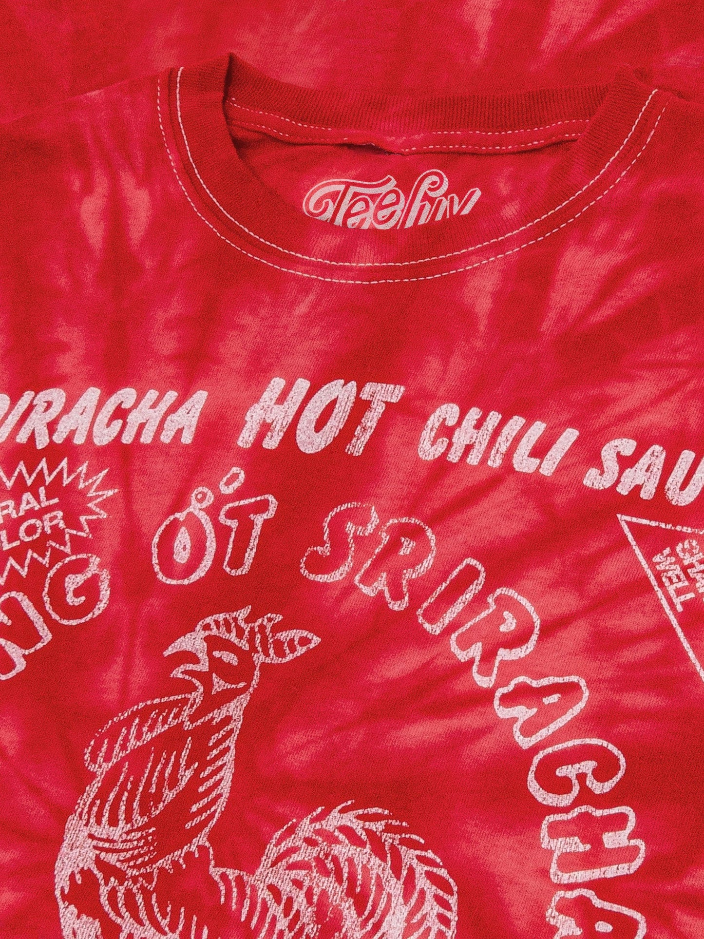 Red t-shirt with white text and graphics, featuring the brand 'Tasha'.