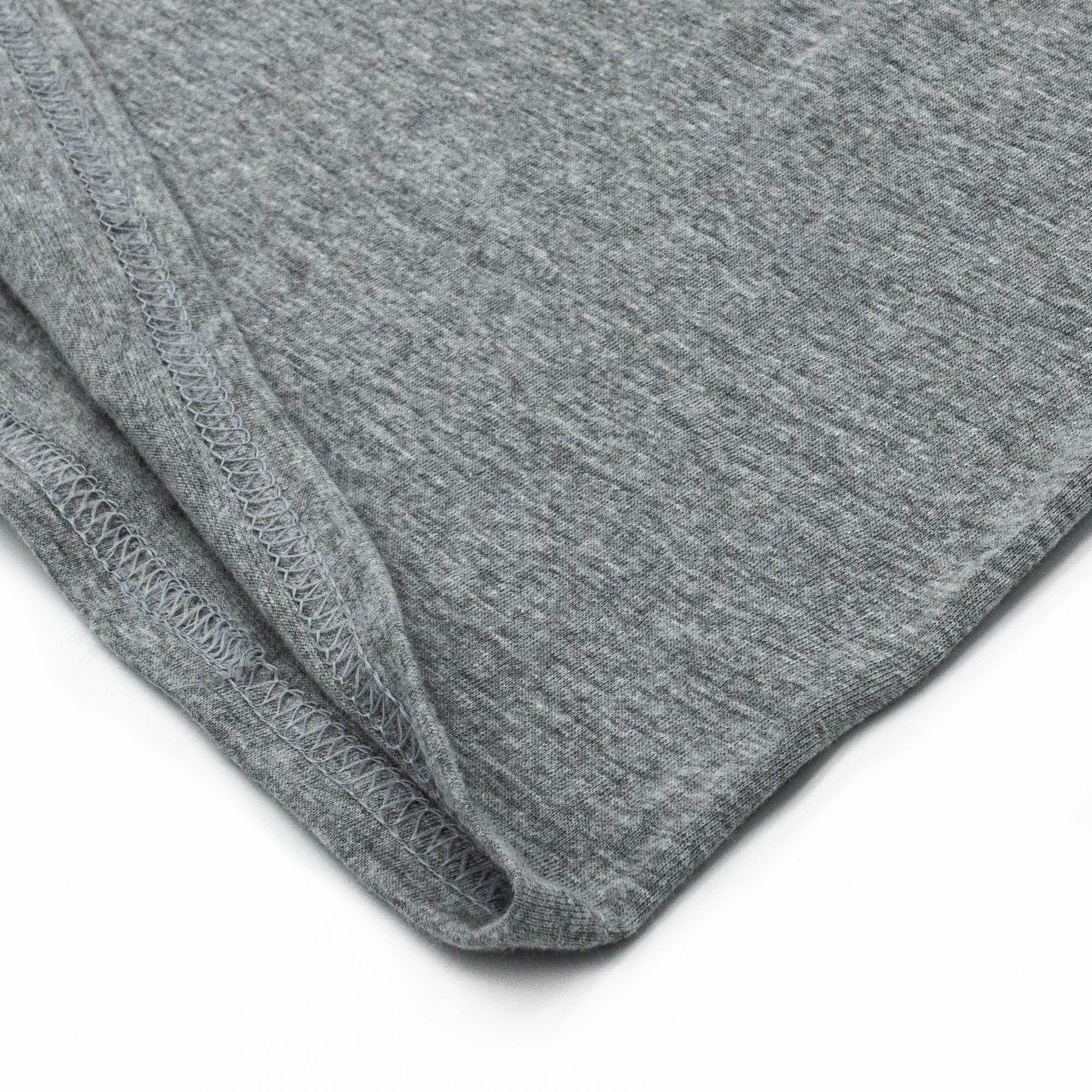 Close-up of gray fabric with a visible seam on a white background
