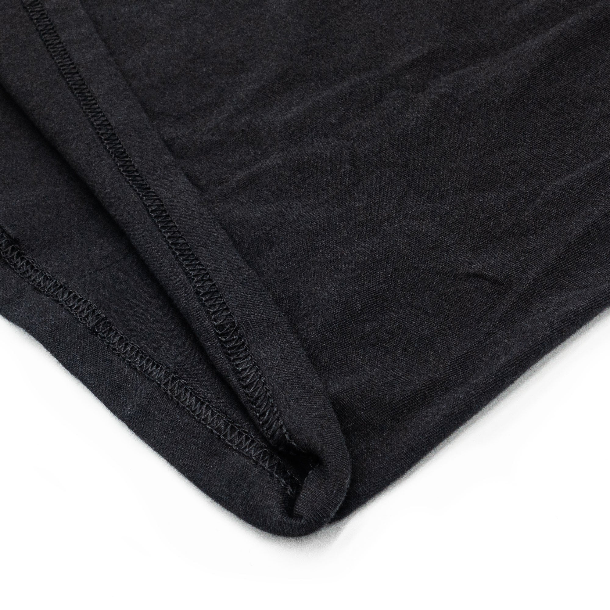 Close-up of a black fabric with a textured pattern on a white background
