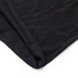 Close-up of a black fabric with a textured pattern on a white background