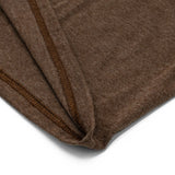 Close-up of a brown fabric with a visible seam on a white background