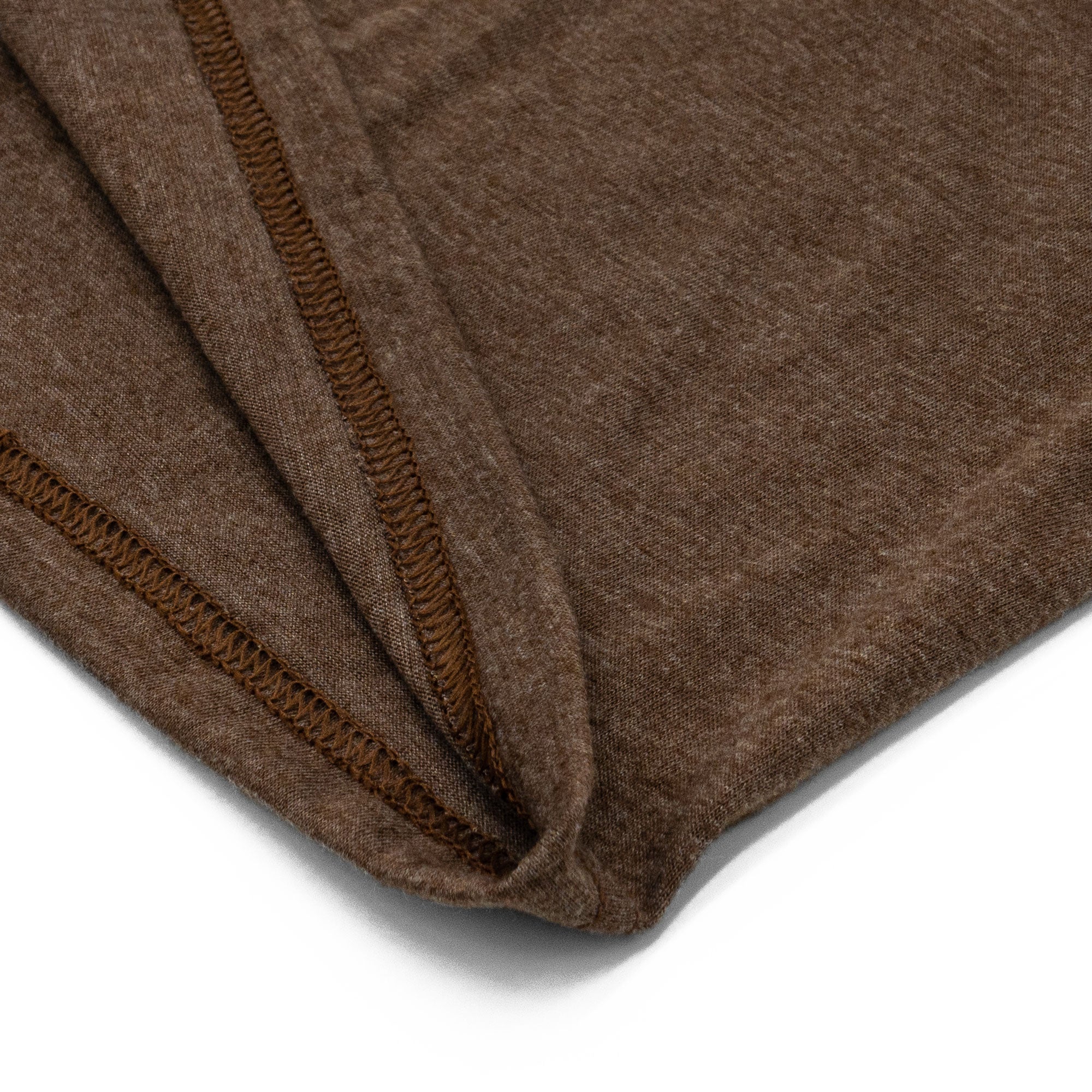 Close-up of a brown fabric with a visible seam on a white background