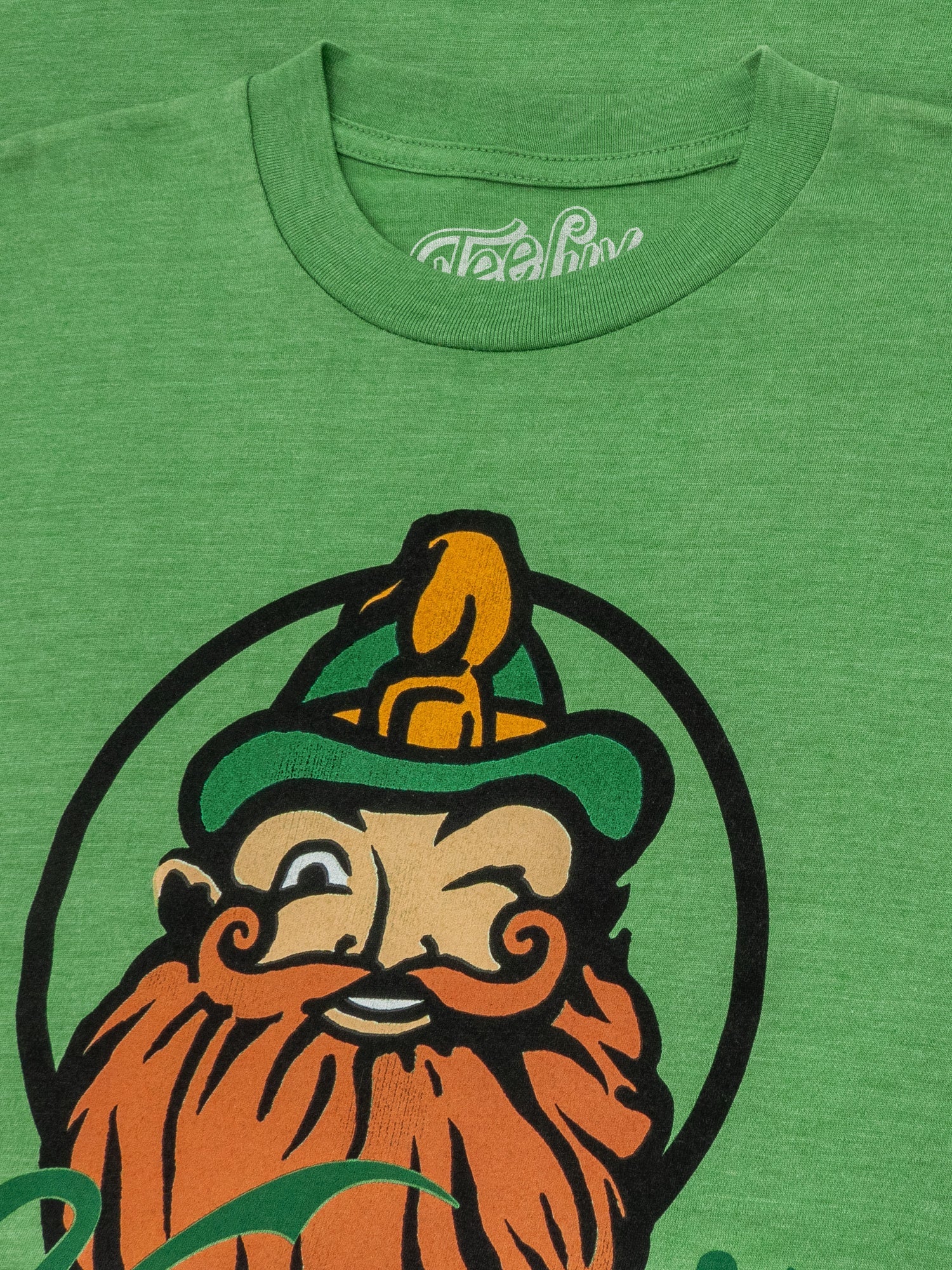 Green t-shirt with a graphic of a bearded man with a bird on his head and 'Folktale' branding.