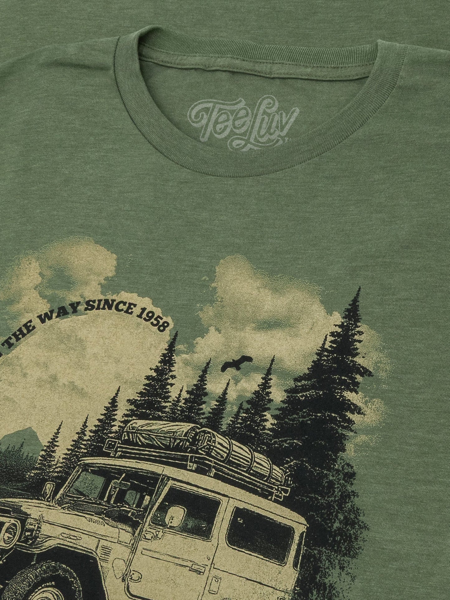 Green t-shirt with a graphic of a vintage car and trees, featuring the brand 'Teely'.