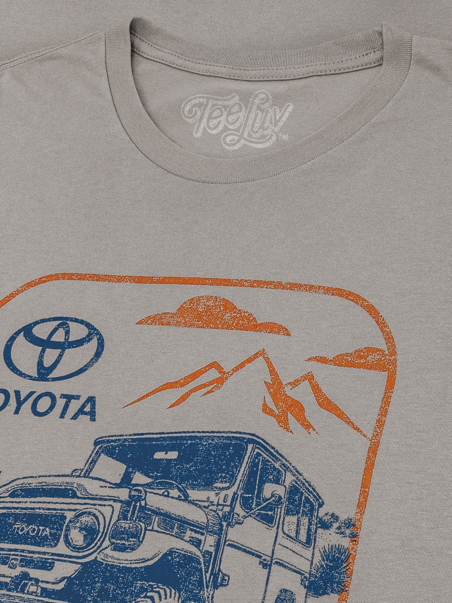 Gray t-shirt with Toyota graphic design featuring a car, mountains, and desert landscape.